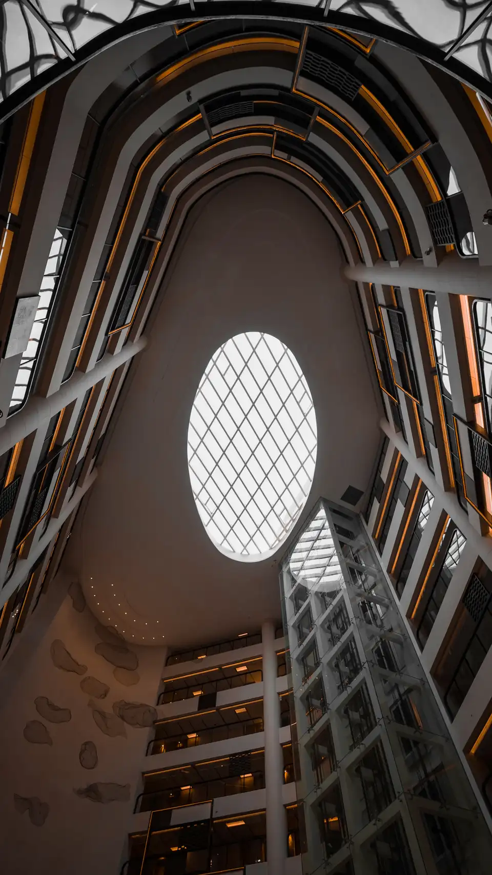 Upward view inside a Shanghai hotel atrium with spiral floors and an oval skylight.